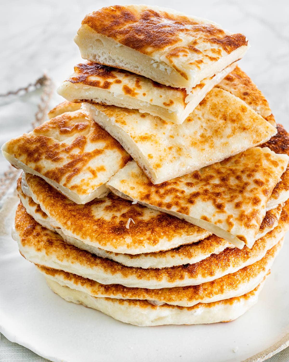 a stack of feta fry bread with the top pieces cut into quarters