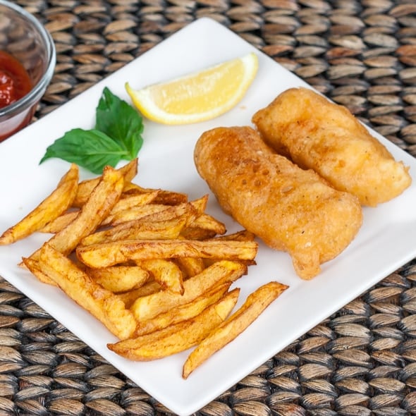 Fish and Chips on a plate with a lemon wedge