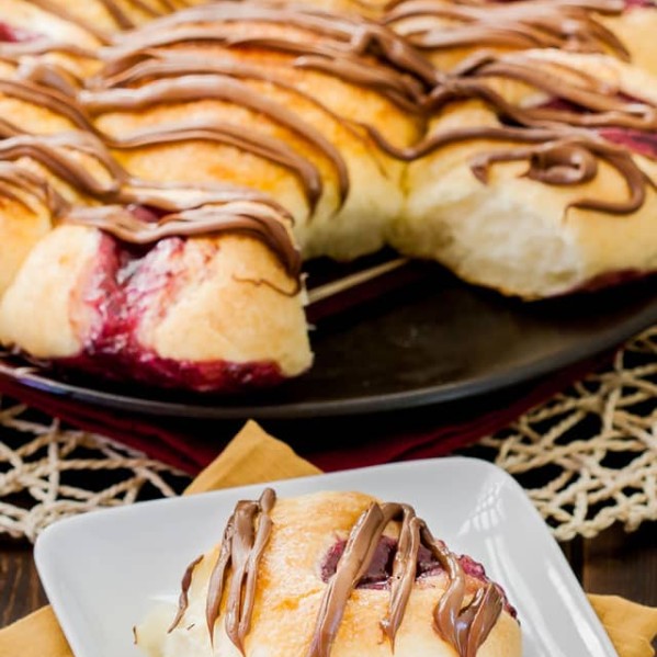 a piece of chocolate and jam pull apart bread on a plate with the rest in the background