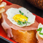 quail egg and pancetta crostini on a plate