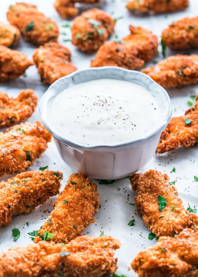 parmesan chicken strips around a bowl of ranch dressing