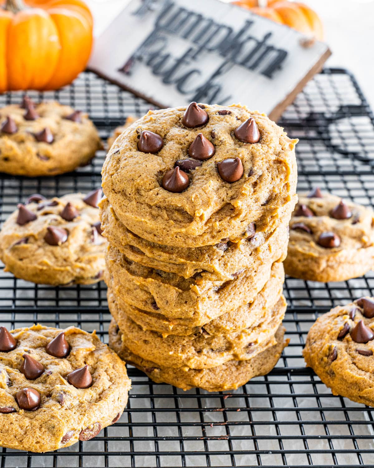 a stack of Pumpkin Chocolate Chip Cookies on a black cooling rack