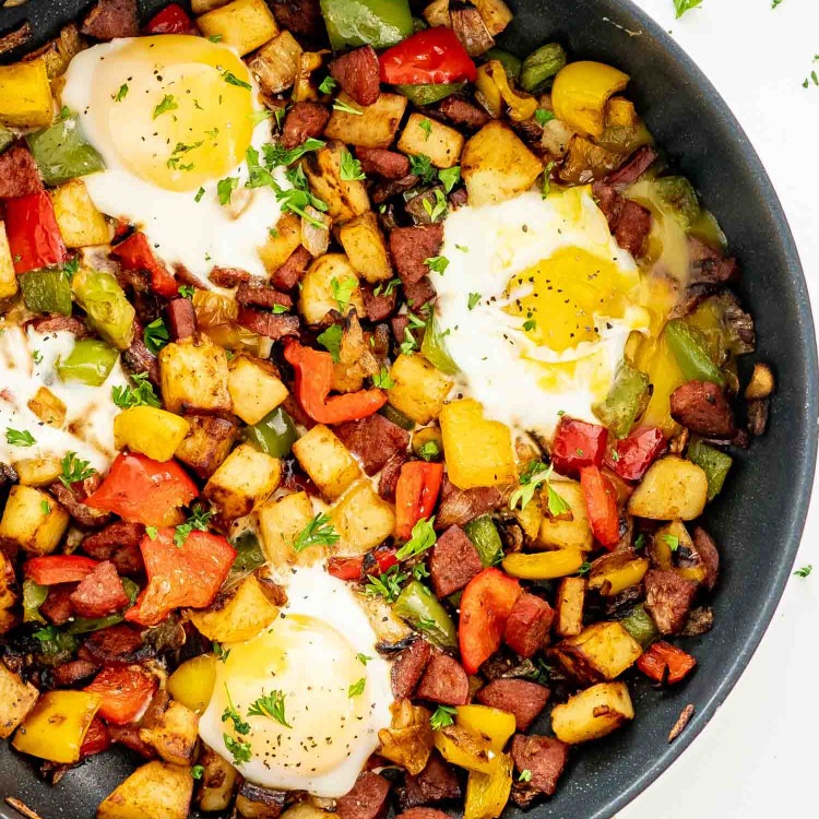 sweet potato hash with eggs in a black skillet.