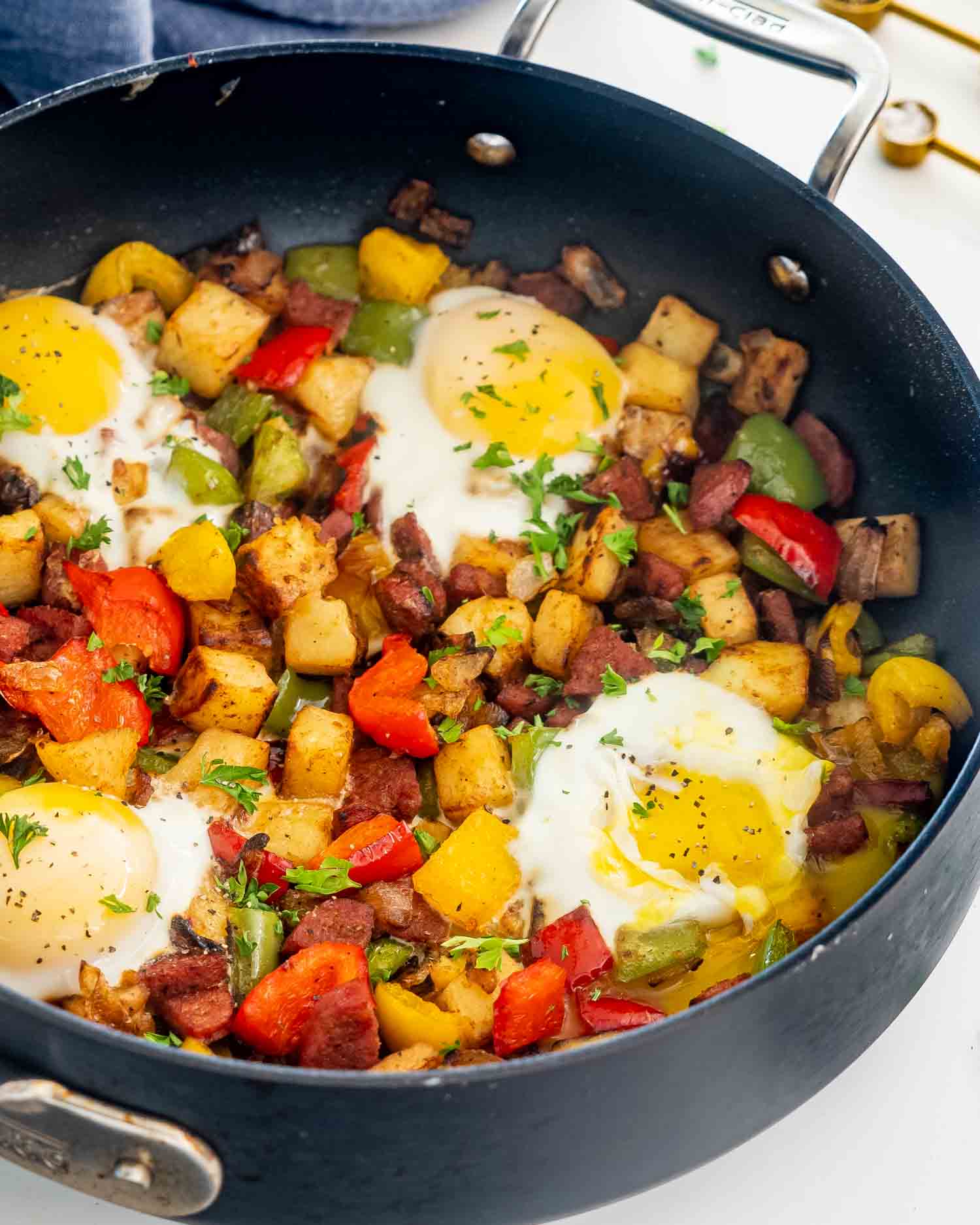 sweet potato hash with eggs in a black skillet.