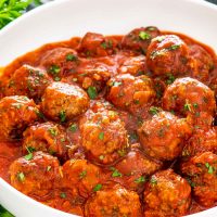italian meatballs with sauce in a white bowl.
