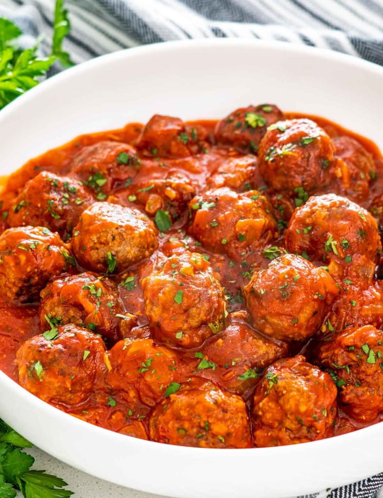 italian meatballs with sauce in a white bowl.