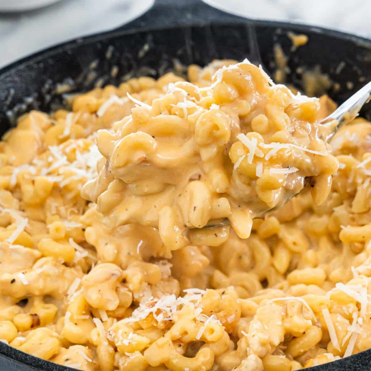 side view shot of a fork taking a bite of chicken mac and cheese