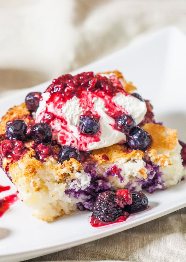 Close up of Fat Free Pineapple Angel Food Cake with a dollop of whipped cream and mixed berries on top