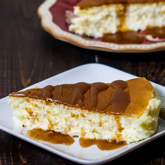 Japanese Cheesecake slice drizzled with caramel sauce on a white plate 