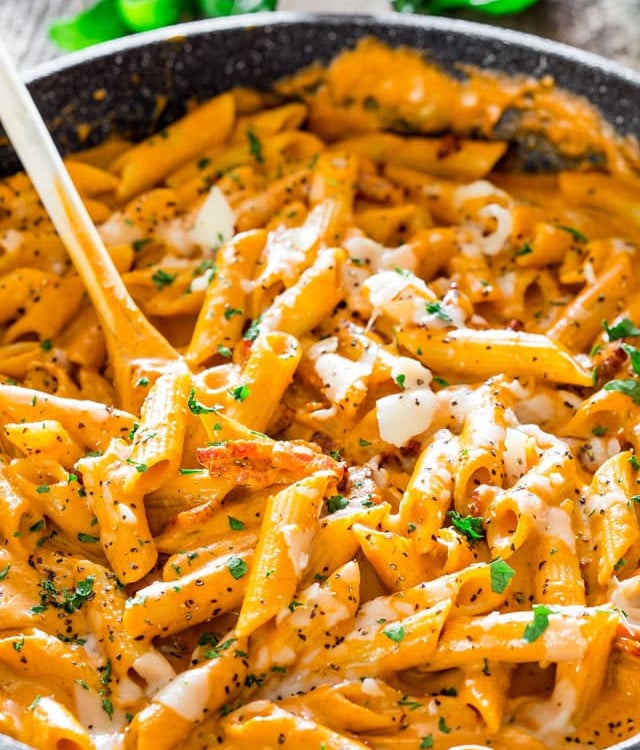 a skillet full of roasted red pepper and pecan pesto penne