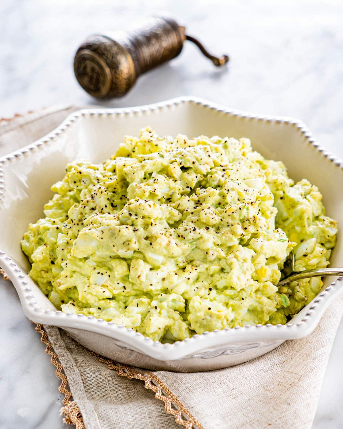 a white bowl filled with avocado egg salad