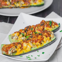 two chicken enchilada stuffed zucchinis on a plate