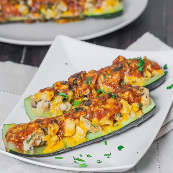 two chicken enchilada stuffed zucchinis on a plate