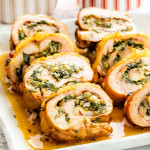 sliced up stuffed chicken thighs with cheese and spinach on a serving platter