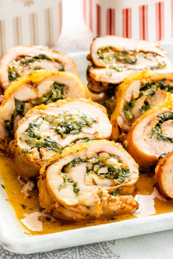 sliced up stuffed chicken thighs with cheese and spinach on a serving platter