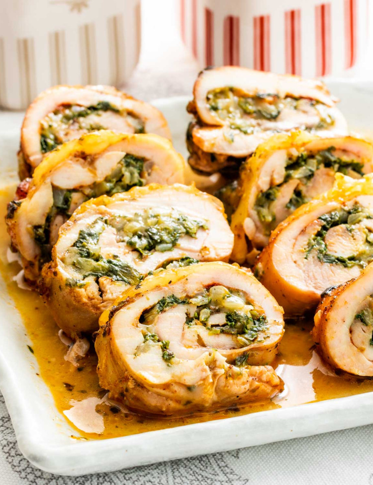 sliced up stuffed chicken thighs with cheese and spinach on a serving platter