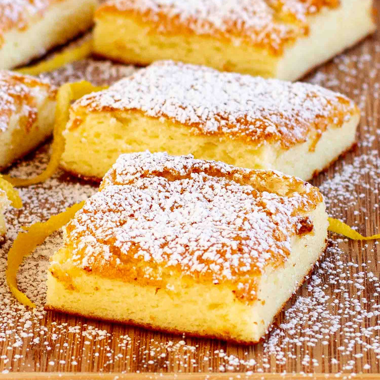2 ingredient lemon bars sprinkled with powdered sugar on a cutting board.