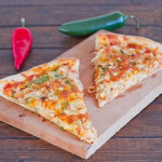 two slices of chicken fajita pizza on a wooden cutting board