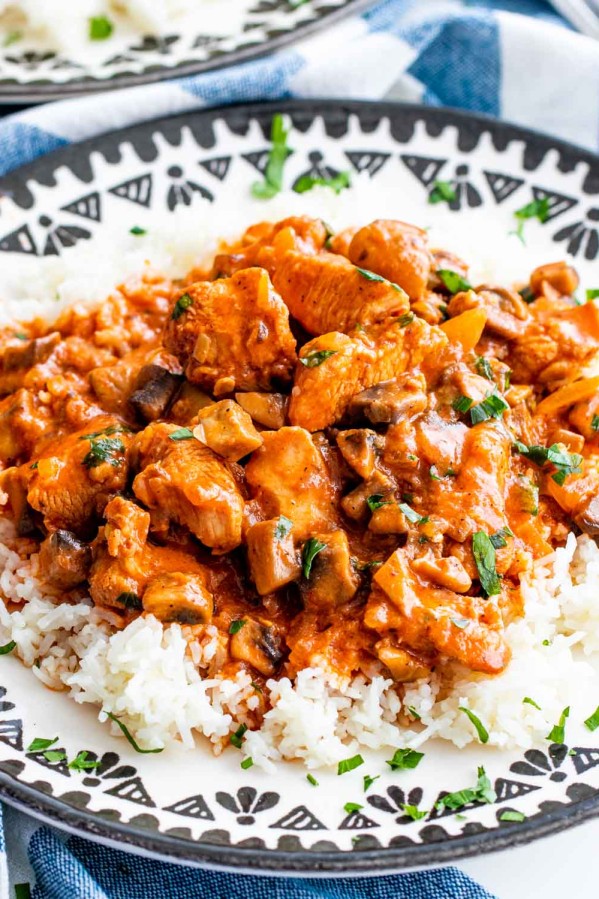 mushroom chicken paprikash over a bed of rice garnished with parsley.
