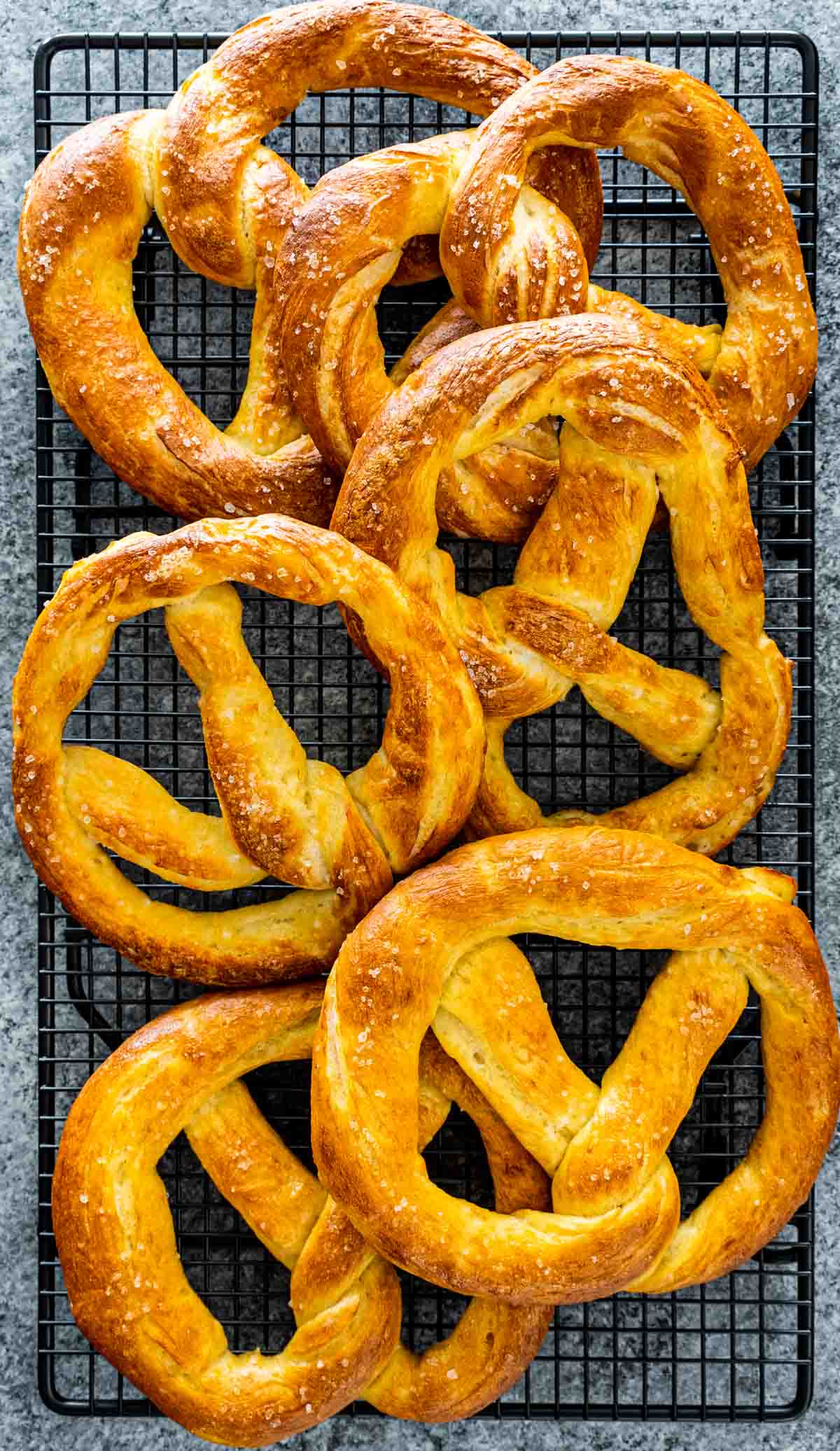 freshly baked soft pretzels cooling on cooling rack.