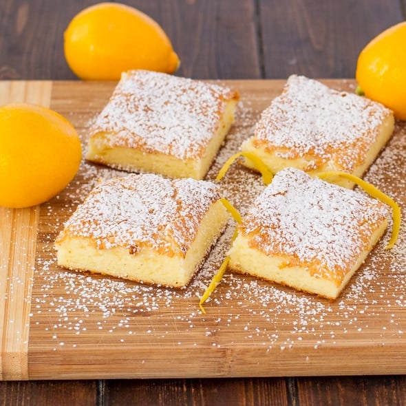 four fat free lemon bars dusted with powdered sugar