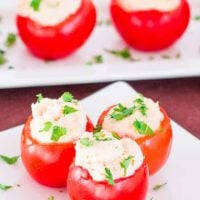 shrimp and crab dip stuffed tomatoes garnished with chopped parsley on a plate