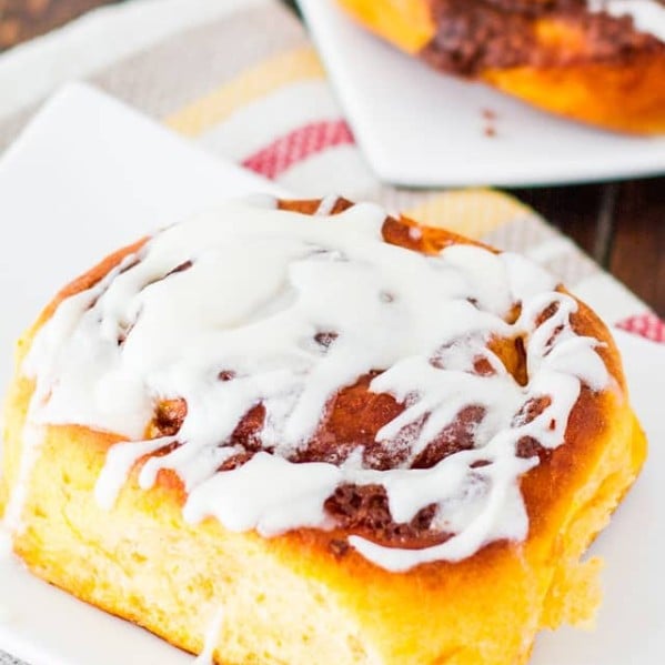 sweet potato cinnamon roll drizzled with icing on a plate