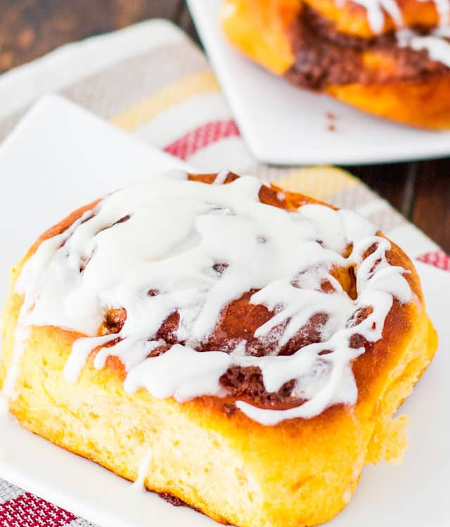 sweet potato cinnamon roll drizzled with icing on a plate