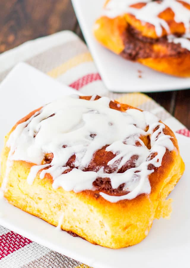 sweet potato cinnamon roll with icing on a white plate