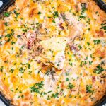 overhead shot of baja spinach dip with a tortilla chip stuck in it