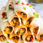 breakfast taquitos stacked into a pyramid on a plate