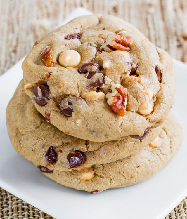 a stack of butterscotch chocolate and pecan cookies on a plate
