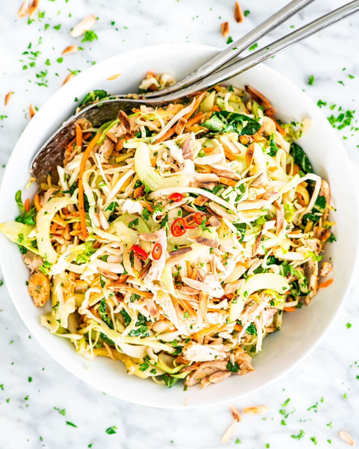 overhead shot of thai chicken salad in a white bowl