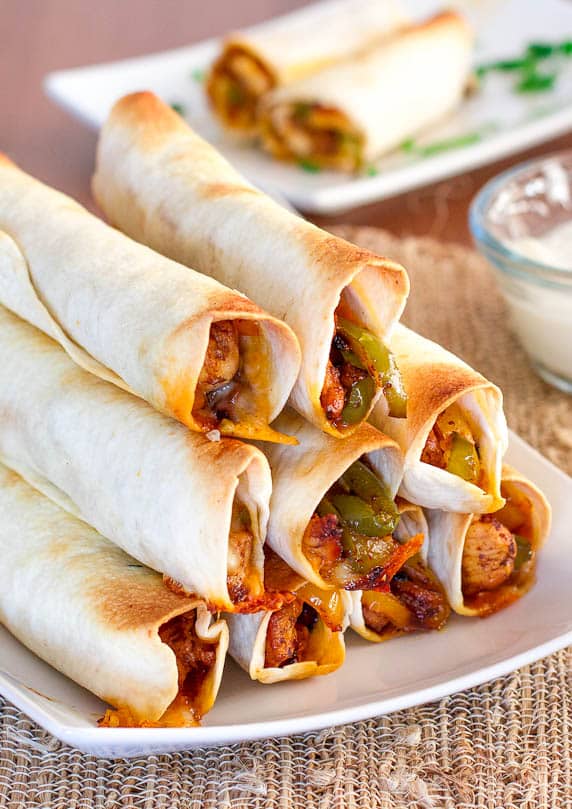 a stack of baked chicken fajita taquitos on a plate