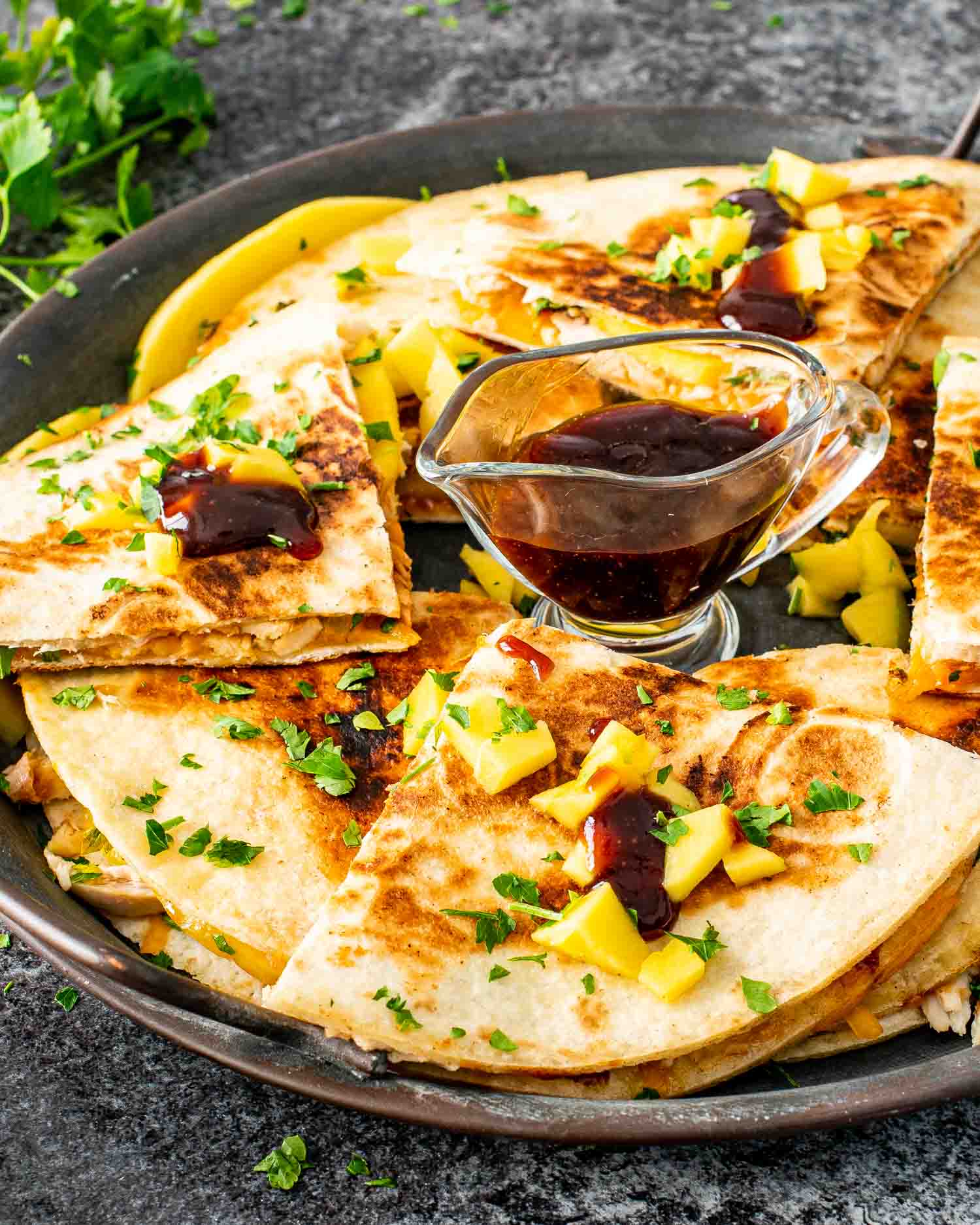 a stack of bbq chicken and mango quesadillas on a metal plate.