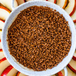 overhead shot of caramel apple dip in a round plate surrounded by apple wedges