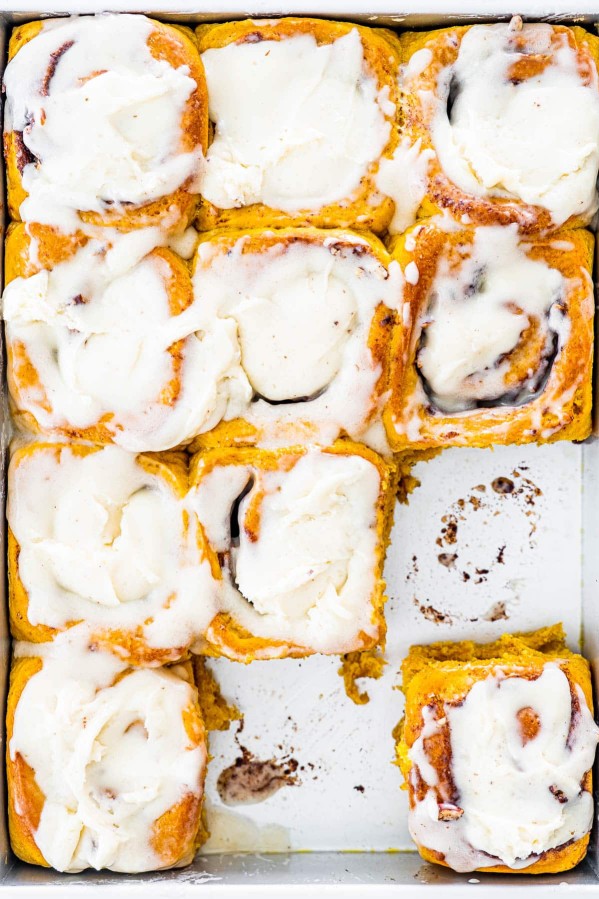 overhead shot of a pan full of pumpkin cinnamon rolls with two missing