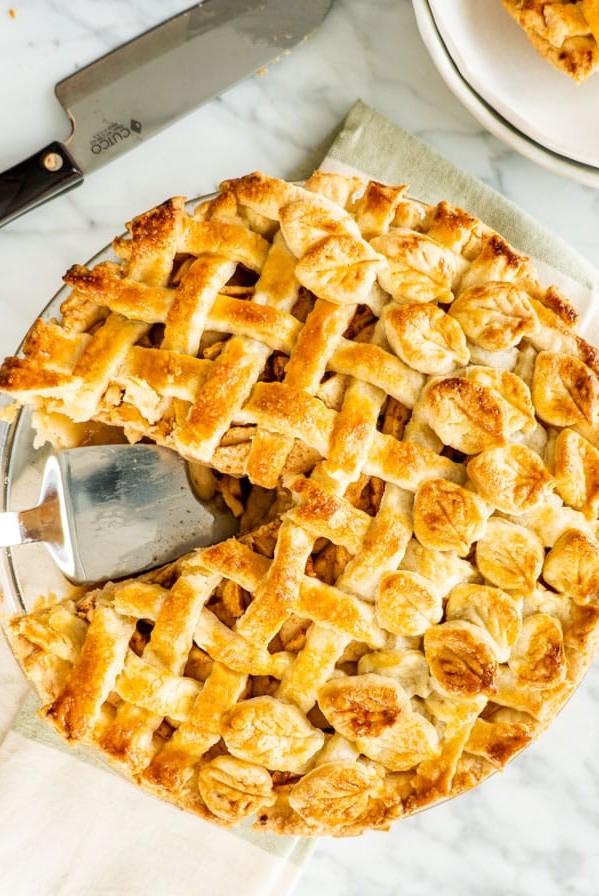 overhead shot of an apple pie with a slice missing and a pie lifter in the empty space