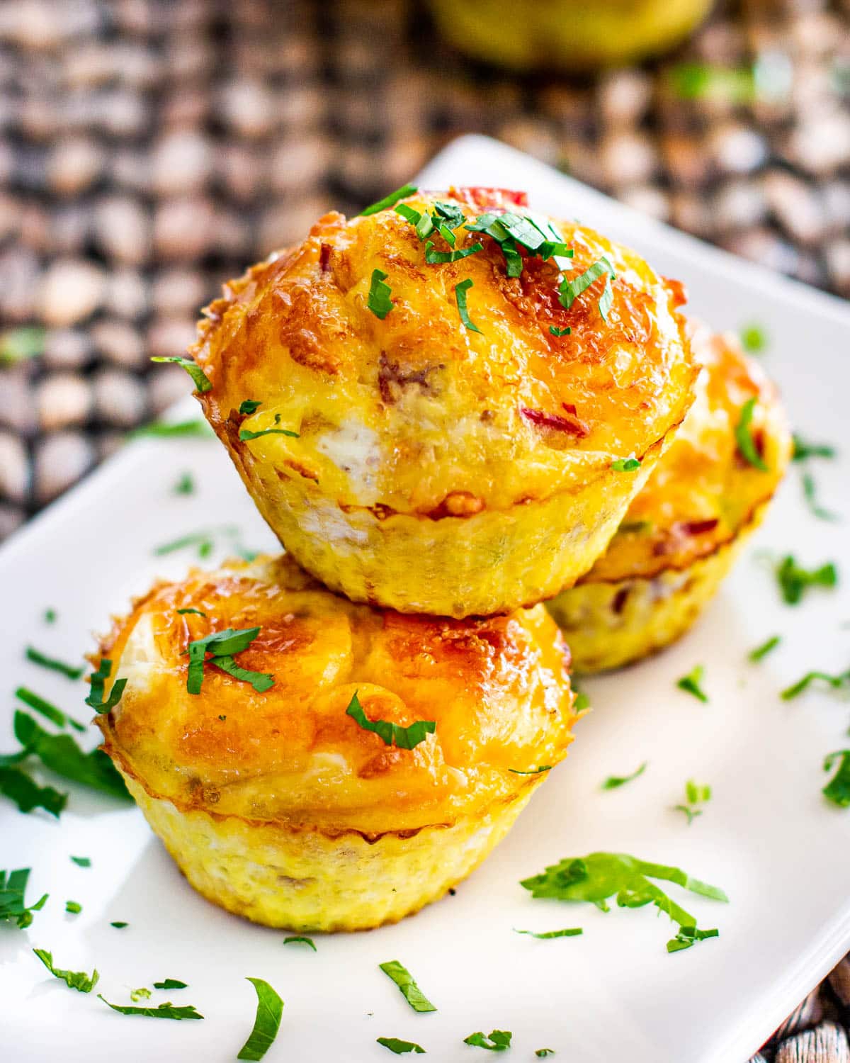 3 egg muffins on a white plate garnished with parsley
