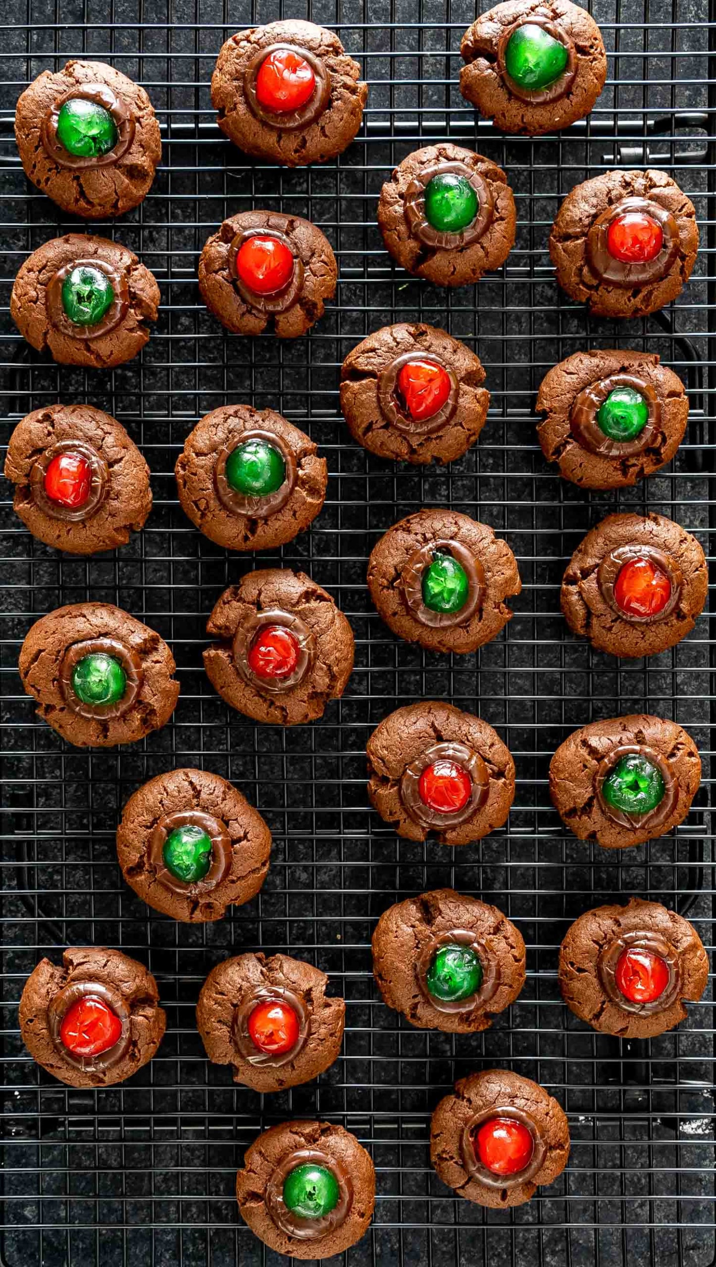 chocolate fudge cookies with maraschino cookies on a cooling rack.