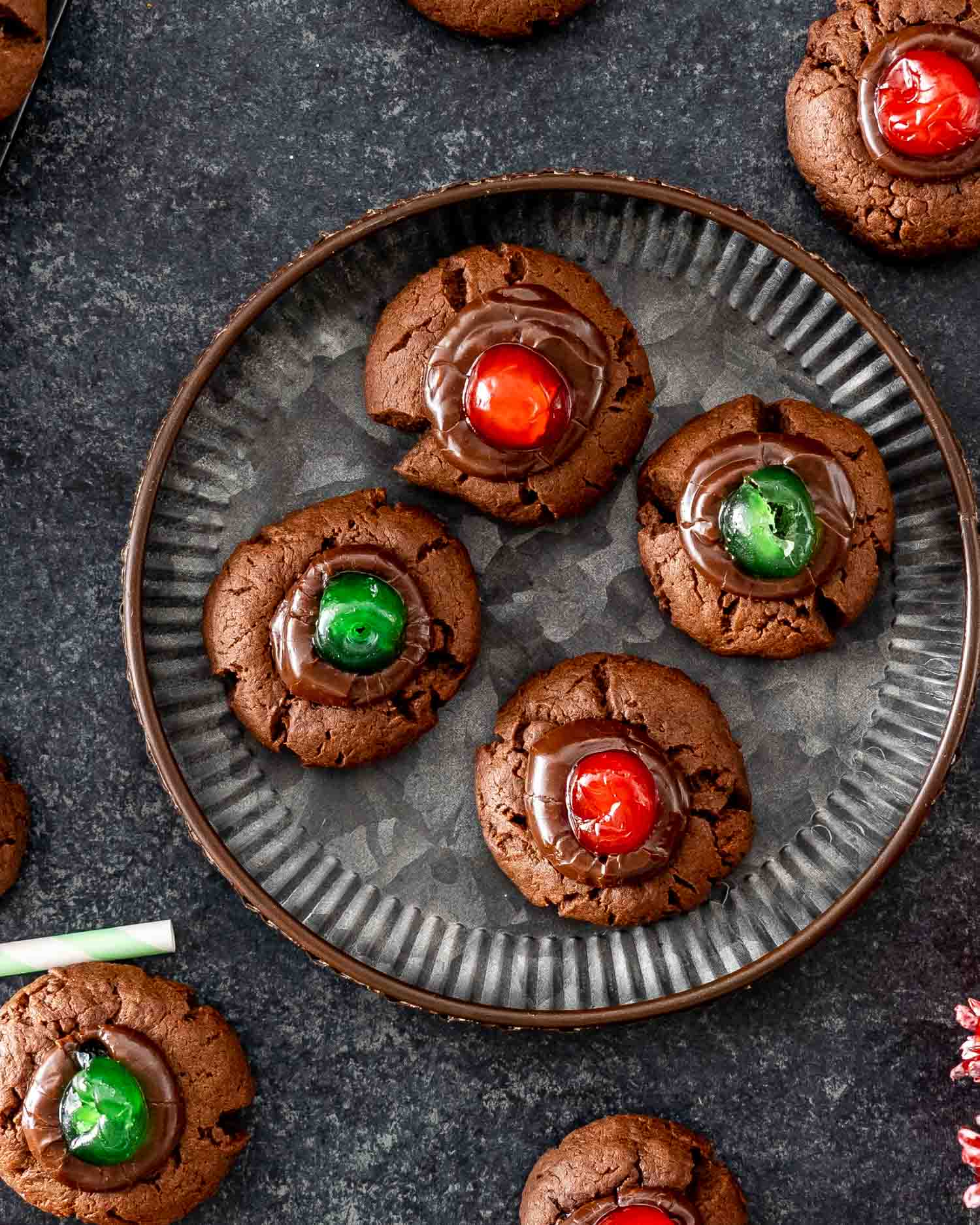 chocolate fudge cookies with maraschino cookies on a plate.