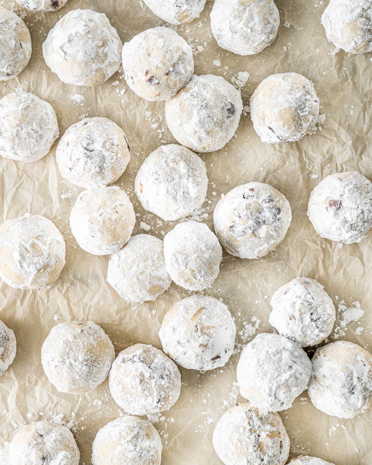 overhead shot of chocolate pecan snowballs on a piece of parchment paper
