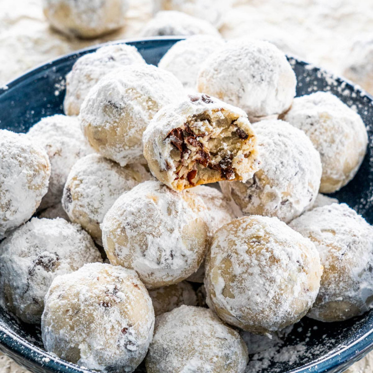 chocolate pecan snowballs on a plate with a bite taken from one