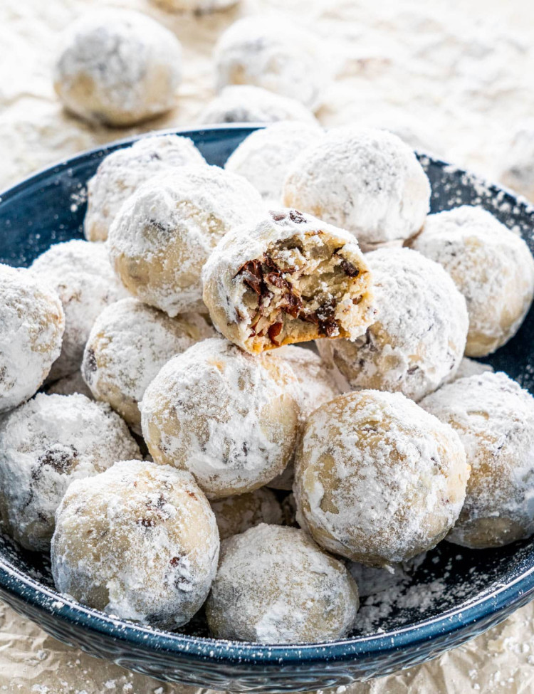 chocolate pecan snowballs on a plate with a bite taken from one