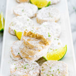 lime meltaway cookies stacked on a plate with a bite taken out of one