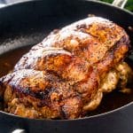 apple stuffed pork loin in a skillet fresh out of the oven.