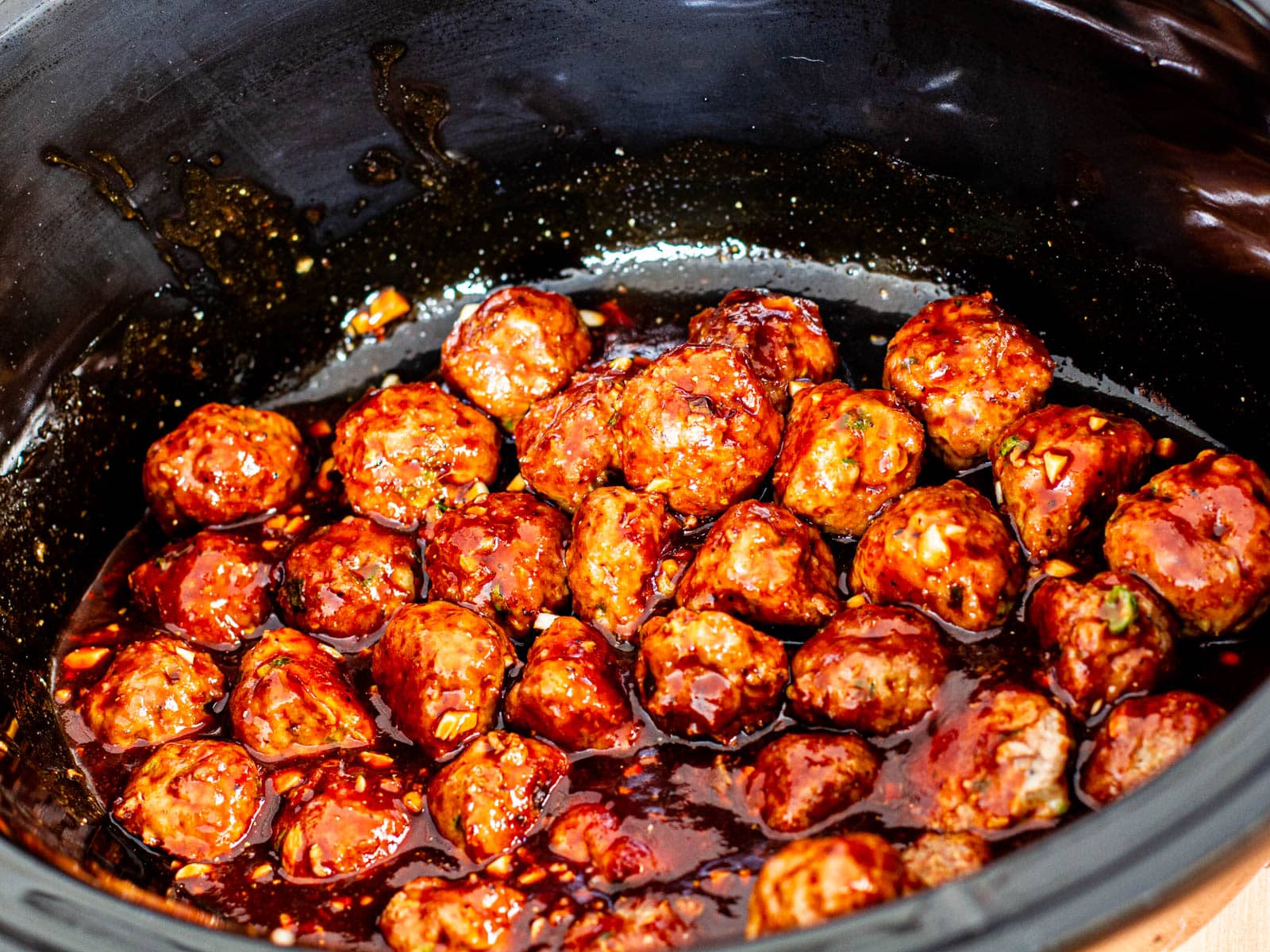 crockpot asian meatballs in sweet and tangy sauce in a slow cooker