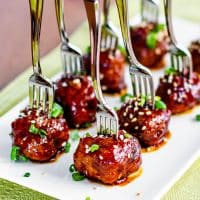 crockpot asian meatballs on a plate with forks stuck in the tops