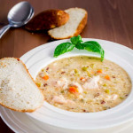 a bowl of wild rice, quinoa and chicken soup with a side of bread