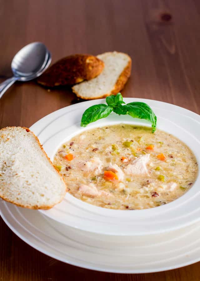 A bowl of Crockpot Wild Rice, Quinoa and Chicken Soup served with a slice of bread
